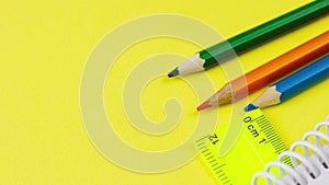 multicolored sharp wooden colored pencils lie on a pastel yellow background with a ruler