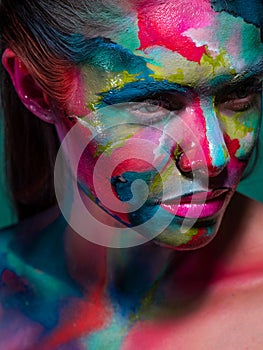 Multicolored skin, difficult to identify. Creative makeup with colorful patterns on the face.