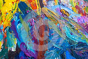 Multicolored small strokes of oil paint in blue, orange, purple shades on canvas, close up. Creative conception of