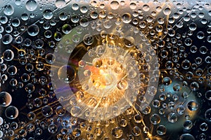 Multicolored spheres are illuminated by a flash of light and are located against a black background with blue and green balls.