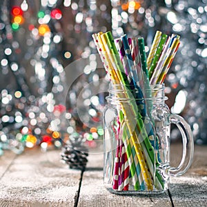 Multicolored spiral straw cocktails in a glass jar Mason on a festive New Year`s background. Sweet table. A table with a drink.
