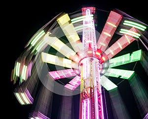 Multicolored Star Flyer tall Carousel rotating on long chains in an amusement park. Entertainment and leisure activities concept