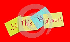 Multicolored sticky notes with christmas theme over a red background