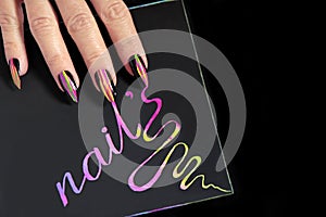 Multicolored striped nail design on long sharp shape with black lacquer.