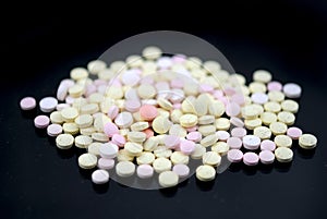 Multicolored tablets closeup with sofl natural shadows and reflection on black background