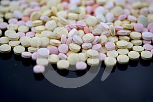 Multicolored tablets closeup with sofl natural shadows and reflection on black background