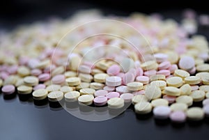 Multicolored tablets closeup with sofl natural shadows and reflection on black background