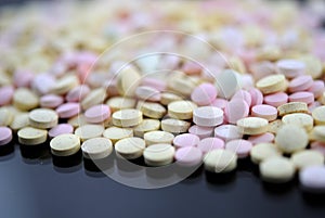 Multicolored tablets closeup with sofl natural shadows and reflection on black background