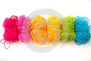 Multicolored threads lie on a white background top view