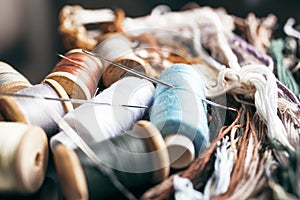 Multicolored threads and needles close-up.