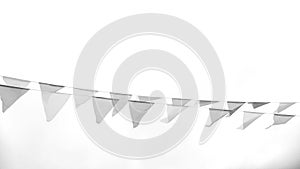 Multicolored triangular flags hang on a string and flutter in the wind against a cloudy cloudy sky