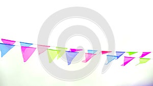 Multicolored triangular flags hang on a string and flutter in the wind against a cloudy cloudy sky