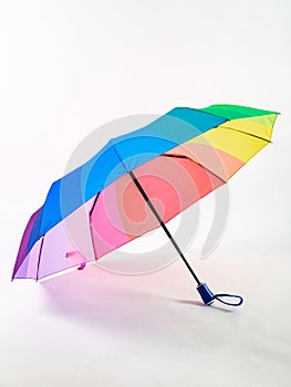 Multicolored umbrella on a white background. The colors of the LGBT community