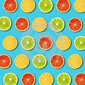 Multicolored vibrant citrus fruit slices texture on turquoise background