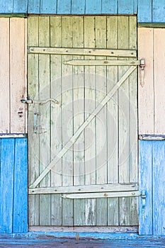 Multicolored vintage facade of an old wooden house with a plank door.