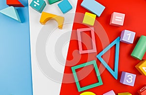 Multicolored wooden blocks on red blue background. Trendy puzzle toys. Geometric shapes: square, circle, triangle, rectangle.