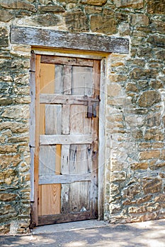 Multicolored Wooden Door against Worn Stone Wall