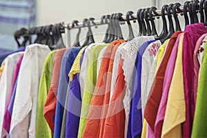 Multicolored youth summer tunic on a hanger. Colorful clothes on hangers for sale in shop. Summer season, assortment in