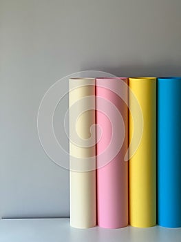 Multicoloured paper in rolls on a simple background