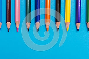 Multicoloured pencils on blue background, back to scool concept photo