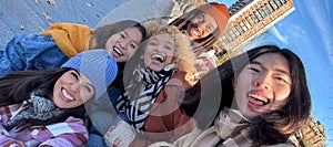 Multicultural best friends having fun taking group selfie portrait outside.