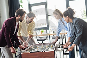 Multicultural business people playing table soccer