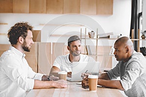 multicultural business people working on laptop at meeting