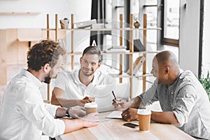 multicultural business people working on laptop at meeting