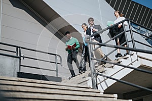 Multicultural business team discussing strategy on outdoor stairway