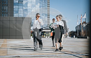 Multicultural business team discussing strategy outdoors with city backdrop