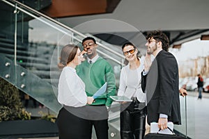 Multicultural business team discussing strategy outdoors near modern office