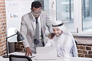 Multicultural businessmen looking at computer photo