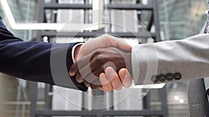 Multicultural businessmen shaking hands during contract signing at workplace