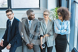 multicultural businesspeople leaning on table