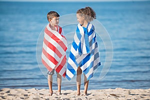 Multicultural children in towels looking at each other while standing