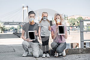 multicultural family with child in protective masks holding gadgets air