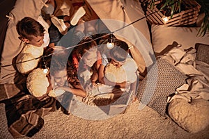 Multicultural group of children reading book together