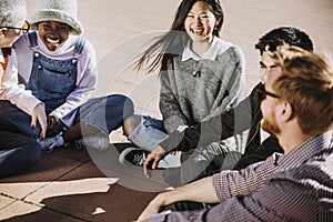 Multicultural group of friends laughing together sitting outside