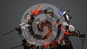 Multicultural group of medieval conquistadors against grey background