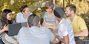 Multicultural group of people discussing by laptop photo