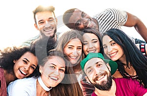 Multicultural guys and girls taking funny selfie - Happy millenial friendship and life style concept photo