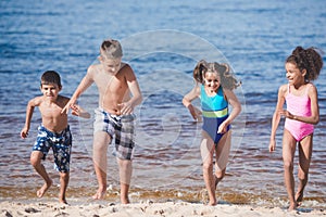 multicultural happy children in swimsuits running photo