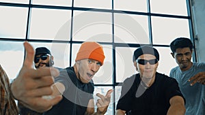 Multicultural hipster looking at camera while perform break dancing. Endeavor.