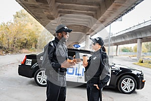 Multicultural police officers with paper cups