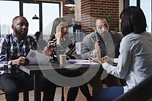 Multicultural recruiters in office talking with job applicant about salary offer.