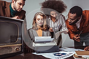 multicultural retro styled friends working in newsroom