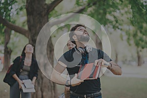 Multicultural students collaborating outdoors on school assignments in park