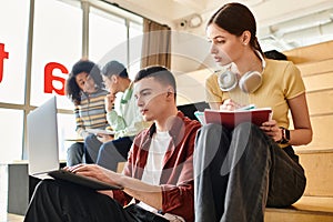 Multicultural students leisurely sitting together on