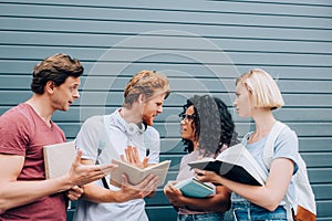 Multicultural students talking while standing with