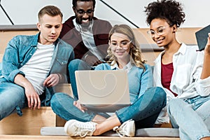 Multicultural students using laptop in lecture hall